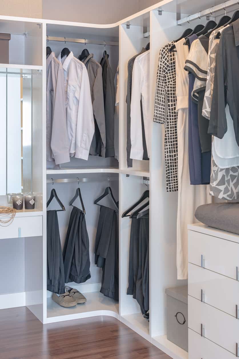 clothes hanging in modern white wardrobe
